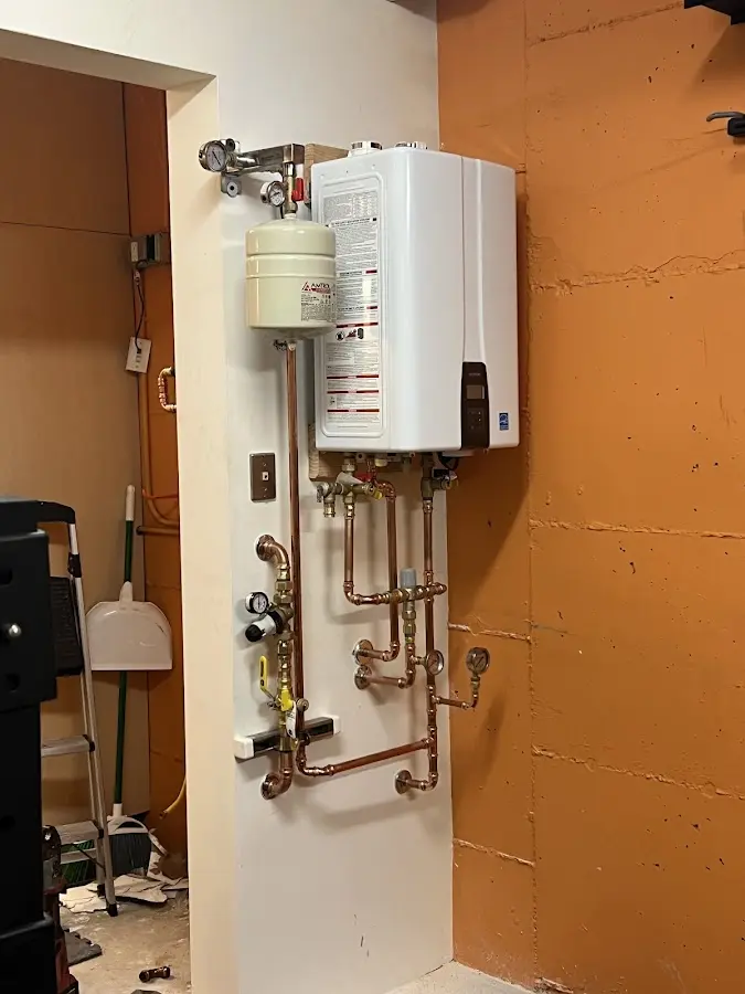 Plumbing technician inspecting water heater connections in Clermont